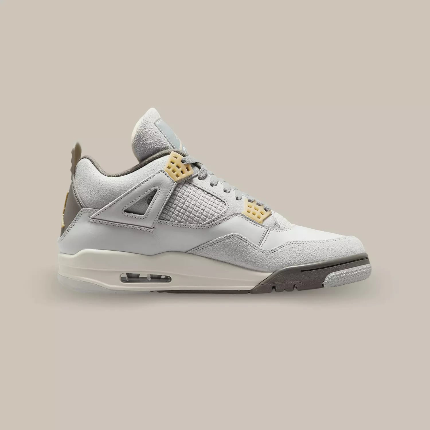 La Air Jordan 4 SE Craft Photon Dust de coté avec sa base en cuir gris et des superpositions en suède gris.