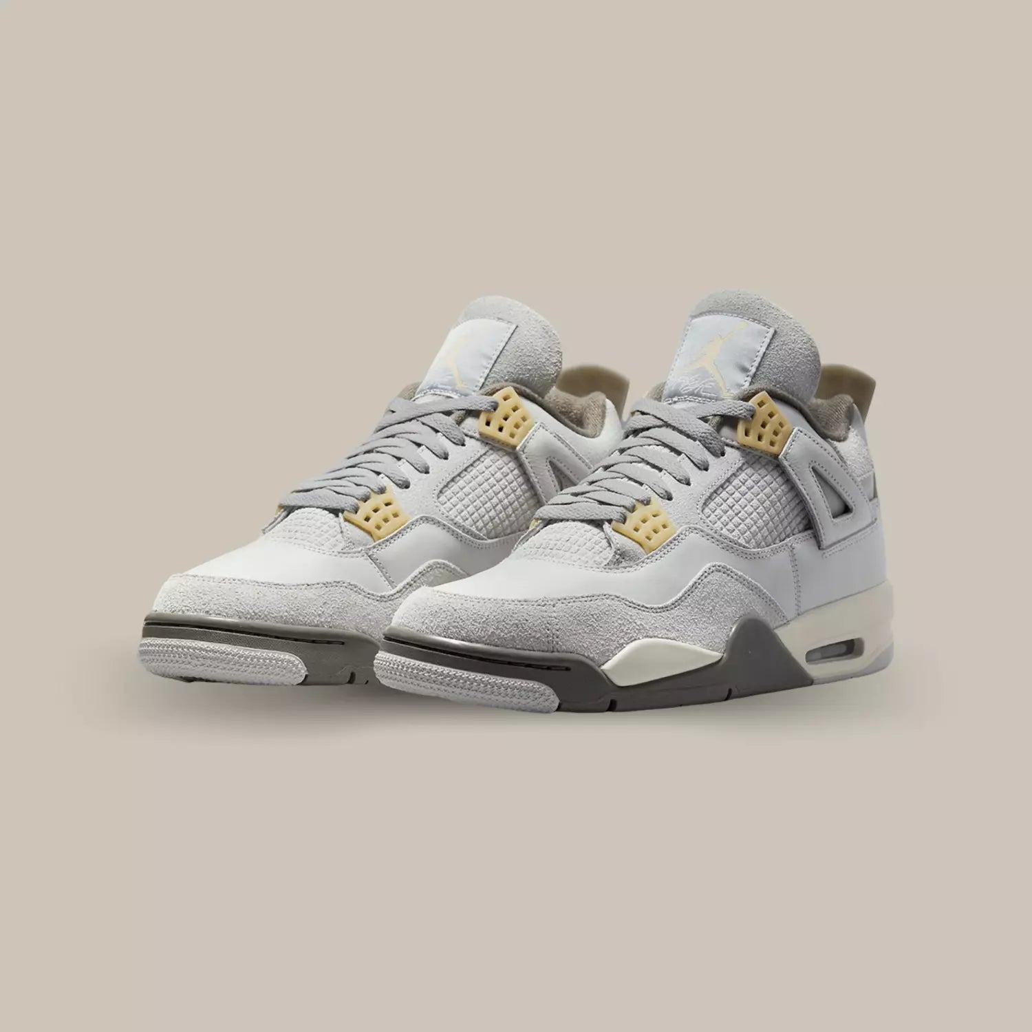 La Air Jordan 4 SE Craft Photon Dust dévoile une base en cuir gris accompagnée de quelque superpositions en suède gris comme le mudguard.