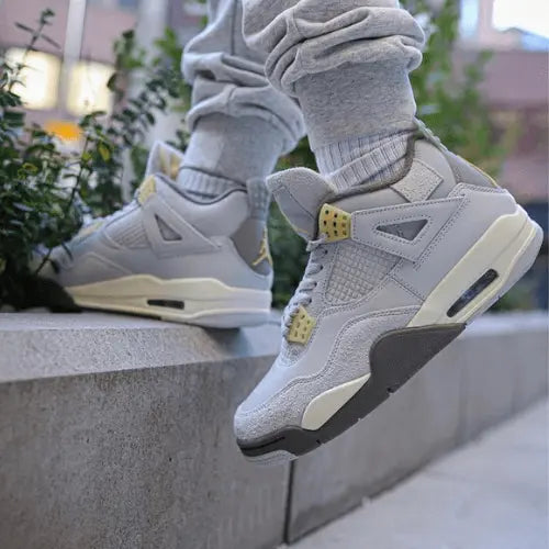 La Air Jordan 4 Craft SE Photon Dust portée avec un jogging gris.