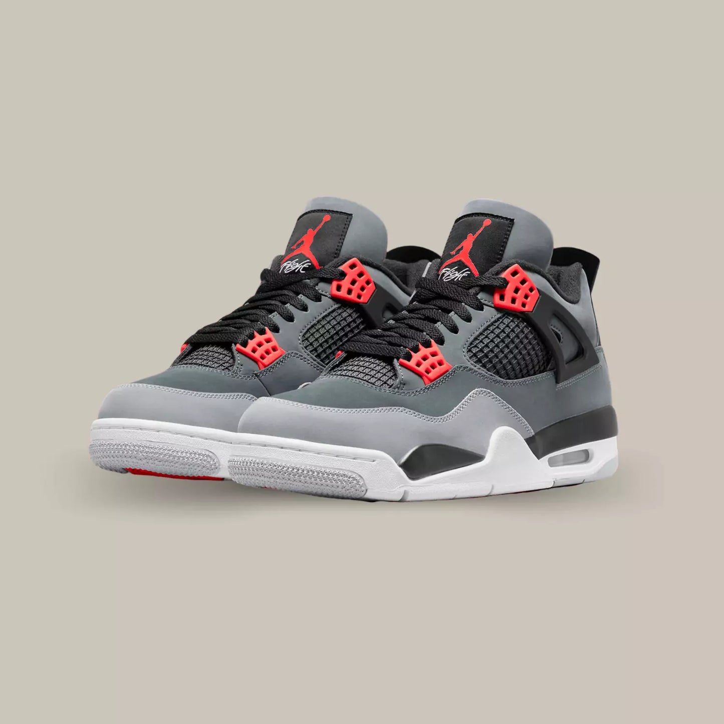 La Air Jordan 4 Infrared (2022) présente une base en daim couleur anthracite, accompagnée de rappels de gris  et de nuances de rouge près des œillets et du Jumpman sur la languette.
