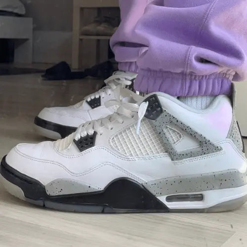 La Air Jordan 4 Midnight Navy portée avec un jogging rose.