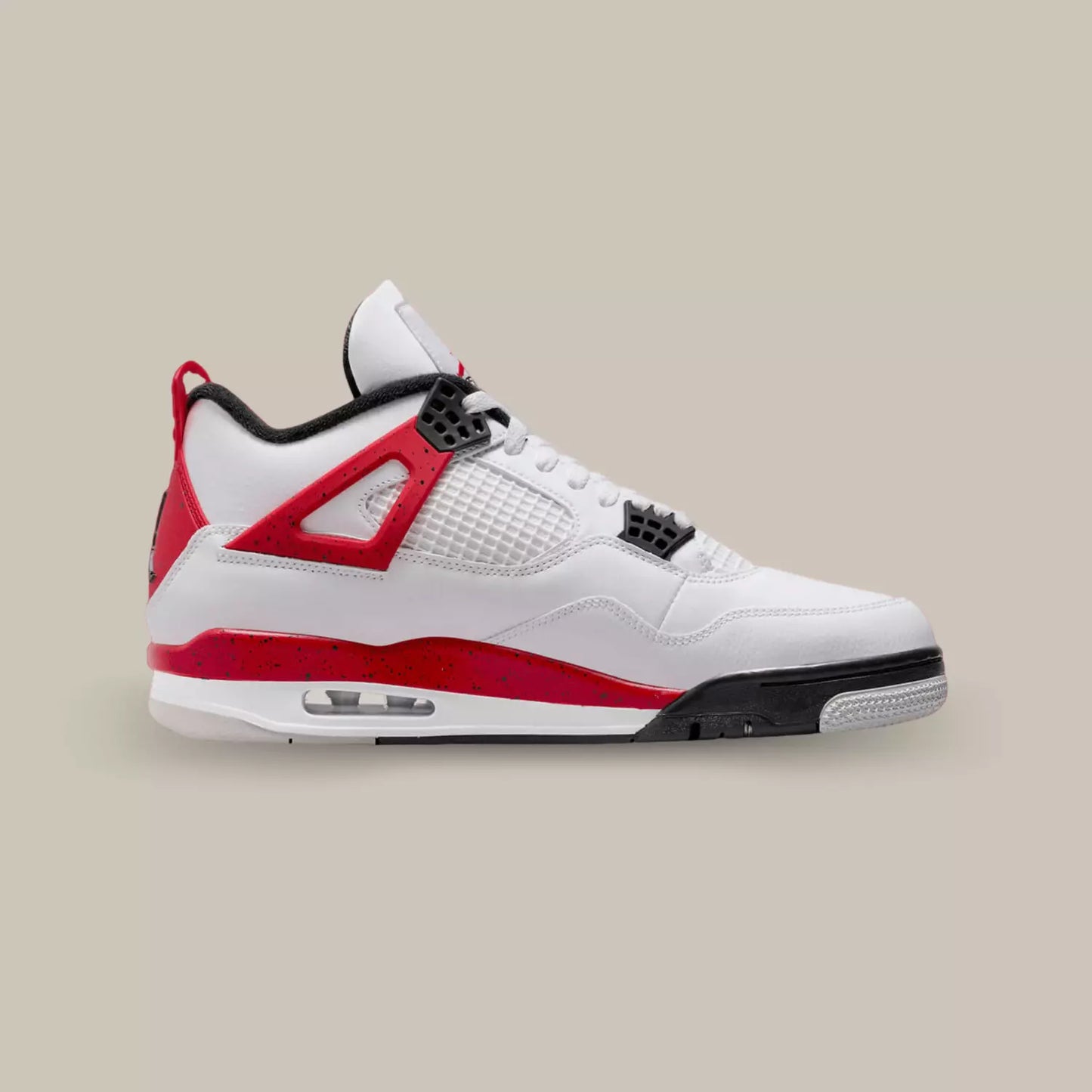 La Jordan 4 Red Cement de coté avec sa base en cuir blanc, des touches de rouges vif sur les wings, le talon et la outsole.