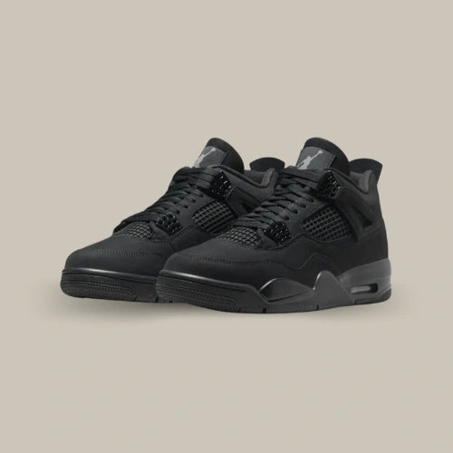 Paire de Air Jordan 4 Retro Black Cat vue de trois quarts avec design total black, lacets noirs et Jumpman gris sur la languette. Disponible sur Offsneakz.