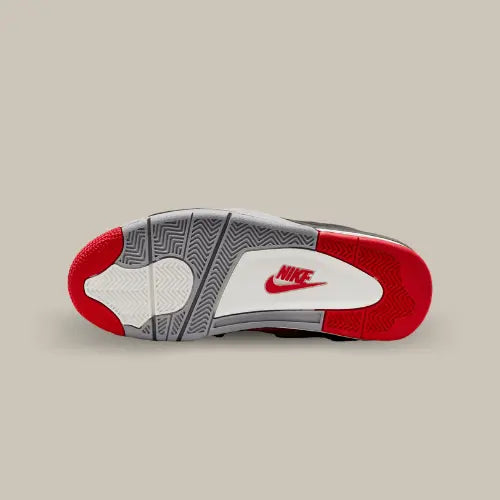 La semelle de la Air Jordan 4 Retro Bred Reimagined de couleur grise, blanche et rouge avec le logo Nike Air de couleur rouge.