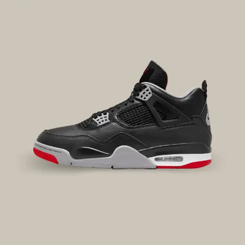 La Air Jordan 4 Retro Bred Reimagined de coté avec sa tige en cuir noir et ses empiècements ton sur ton.