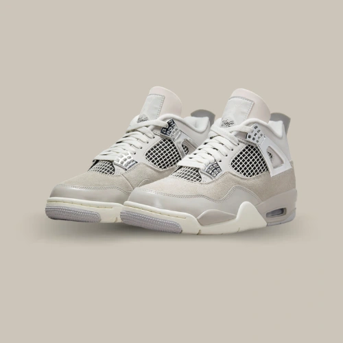 Paire de Air Jordan 4 Retro Frozen Moments grise et Sail avec détails chromés, vue de trois quarts – disponible sur OFFSNEAKZ.