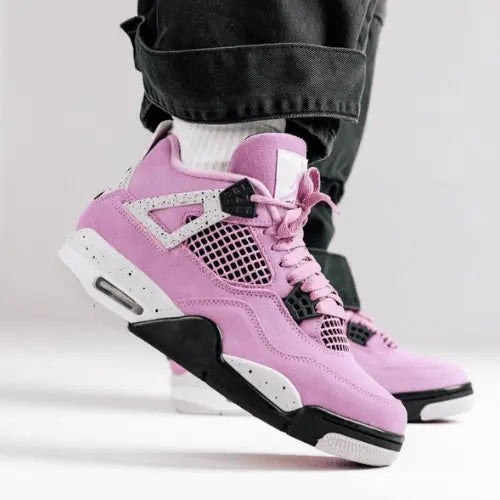 La Air Jordan 4 Retro Orchid portée avec un jean large à ourlet noir.