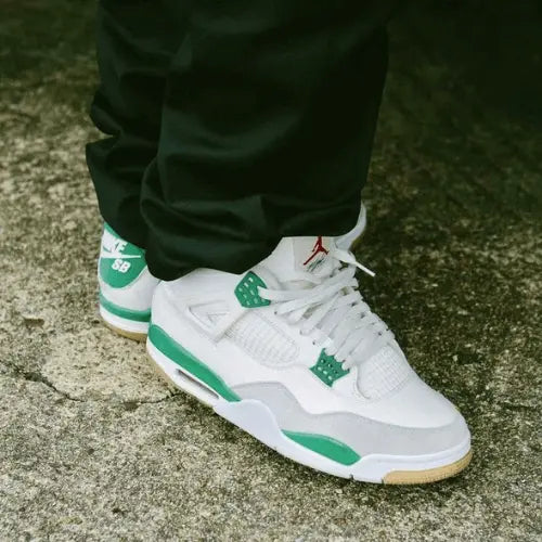 L Air Jordan 4 Retro SB Pine Green portée avec un pantalon vert.