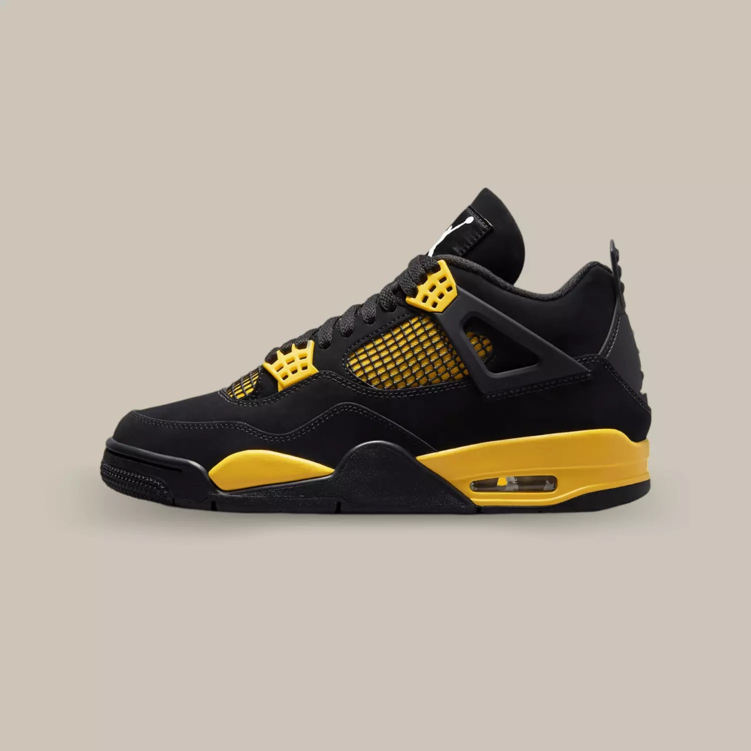 La Air Jordan 4 Retro Thunder de coté avec sa base en nubuck noir, sa cage jaune et noir et ses œillets jaunes.