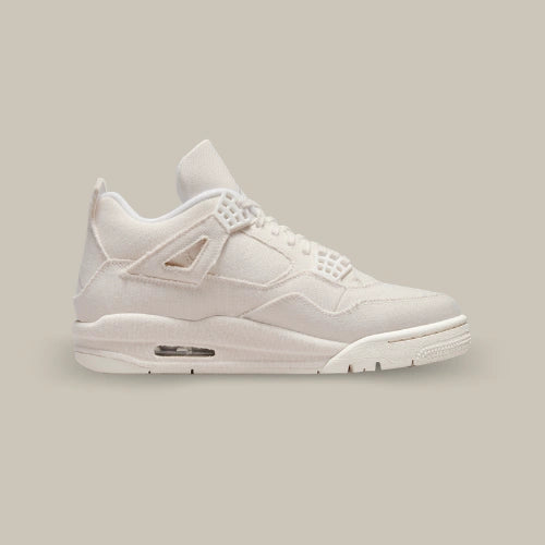 Air Jordan 4 Sail Canvas vue du profil opposé avec construction monochrome blanc cassé et touches rouge et bleue sous la semelle. Disponible sur Offsneakz.
