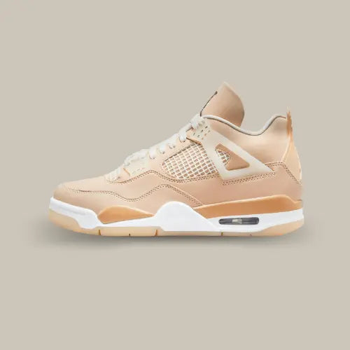 La Air Jordan 4 Shimmer de coté avec sa tige en cuir oscillant entre le beige et le rose pâle.