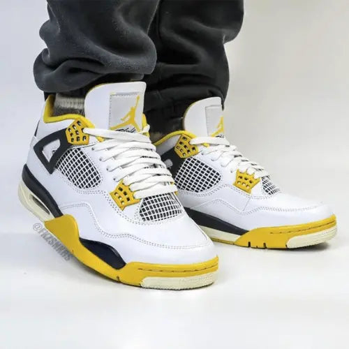 La Air Jordan 4 Vivid Sulfur portée avec un jogging noir.
