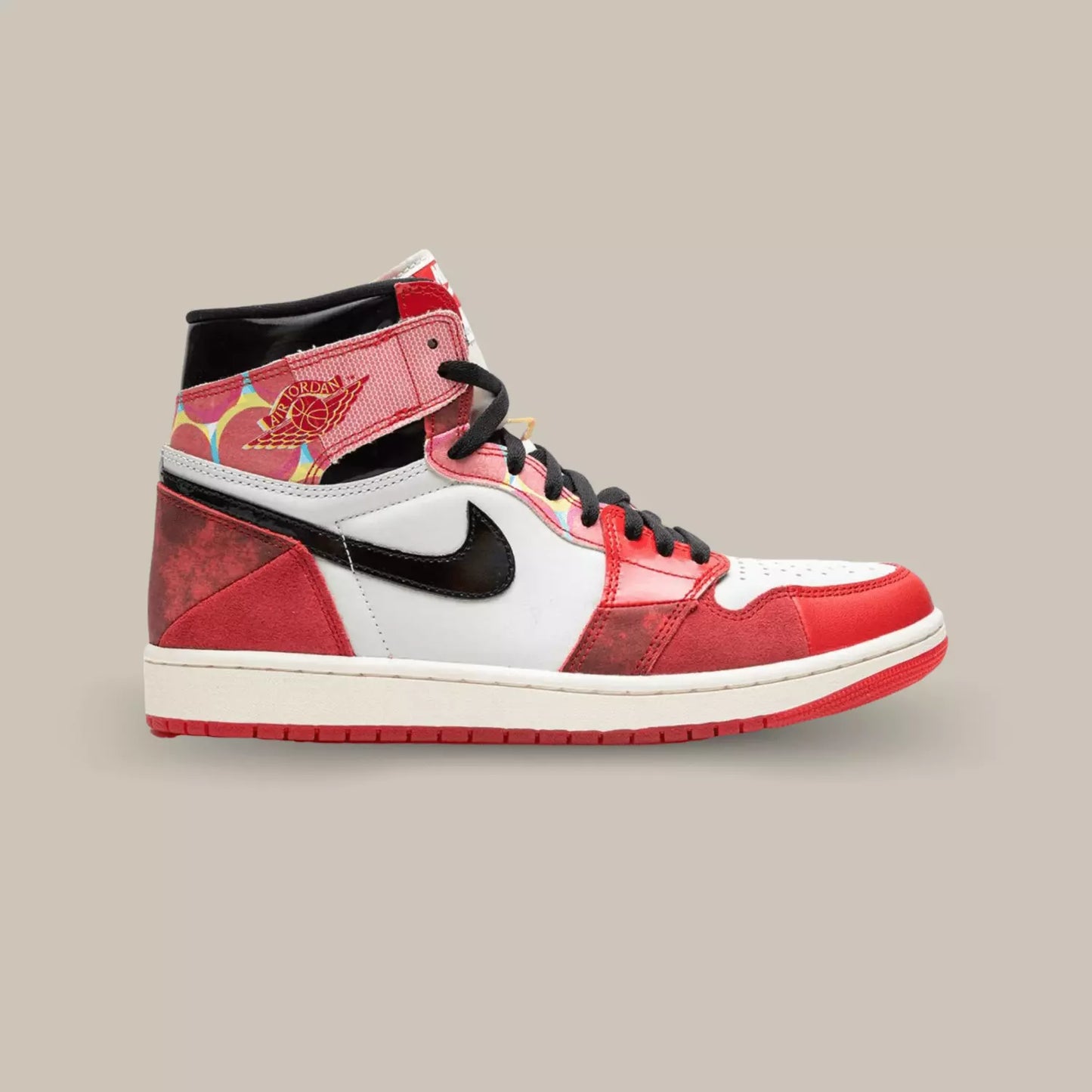 La Air Jordan 1 High OG Spider-Man Across the Spider-Verse de coté avec sa  base de cuir blanc et ses superpositions de cuir et de daim rouge.