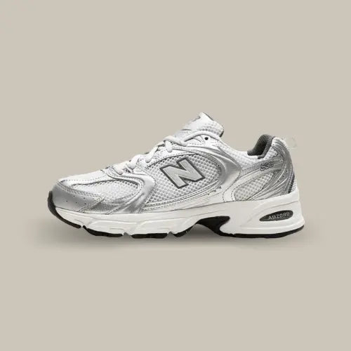 La New Balance 530 Grey Matter Silver Metallic vue de côté avec sa base blanche et ses empiècements argentés.
