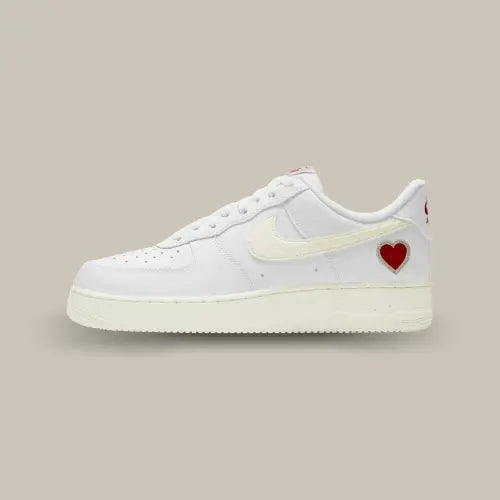 La Nike Air Force 1 Low Valentine's Day (2021) de coté avec son cuir blanc, ses touches de crème et son cœur rouge posé sur le talon.