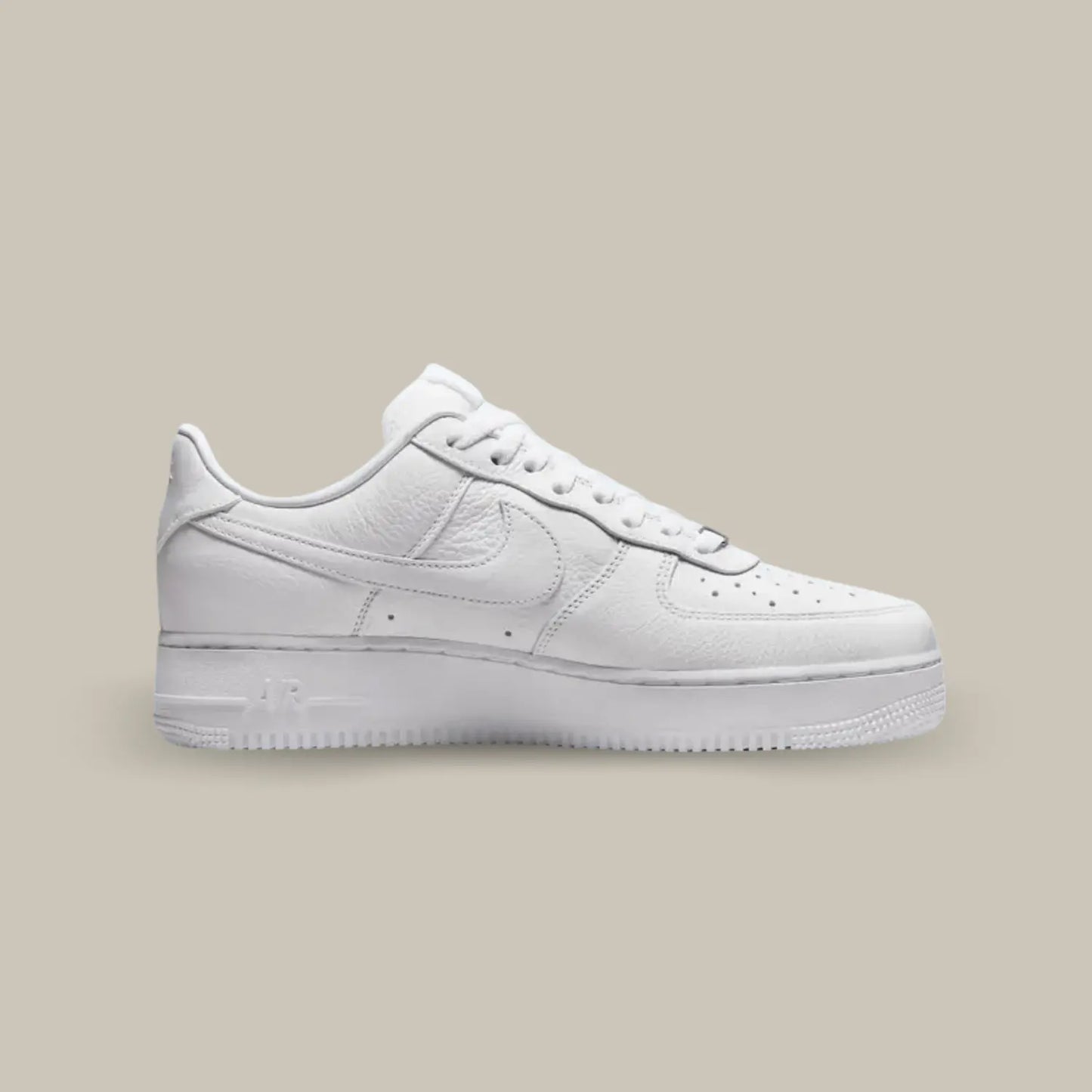 La Nike Air Force 1 NOCTA de coté avec sa base en cuir blanc et le "AIR" de la semelle remplacée par "Love you forever".