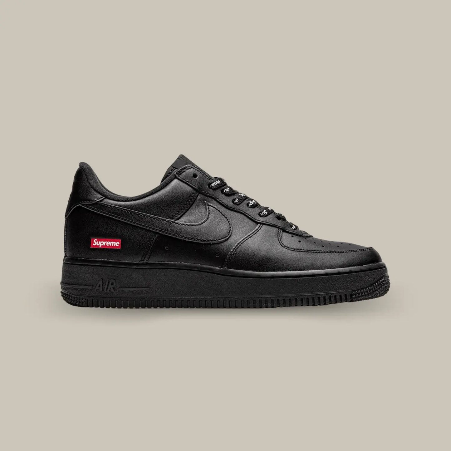 La Nike Air Force 1 Low Black Supreme de coté avec son cuir noir et son petit logo spreme au niveau du talon.