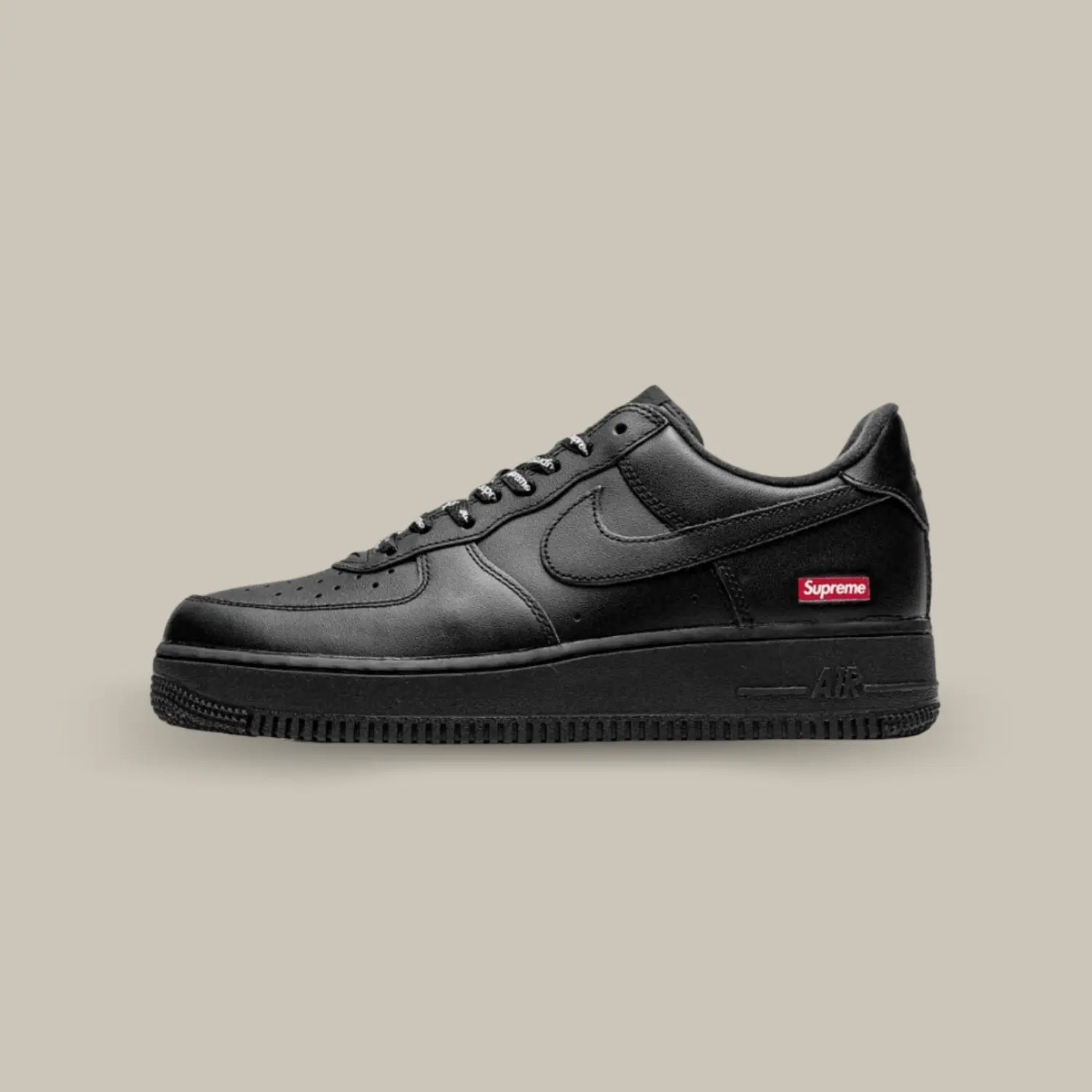 La Nike Air Force 1 Low Black Supreme de coté avec son cuir noir et son petit logo spreme au niveau du talon.