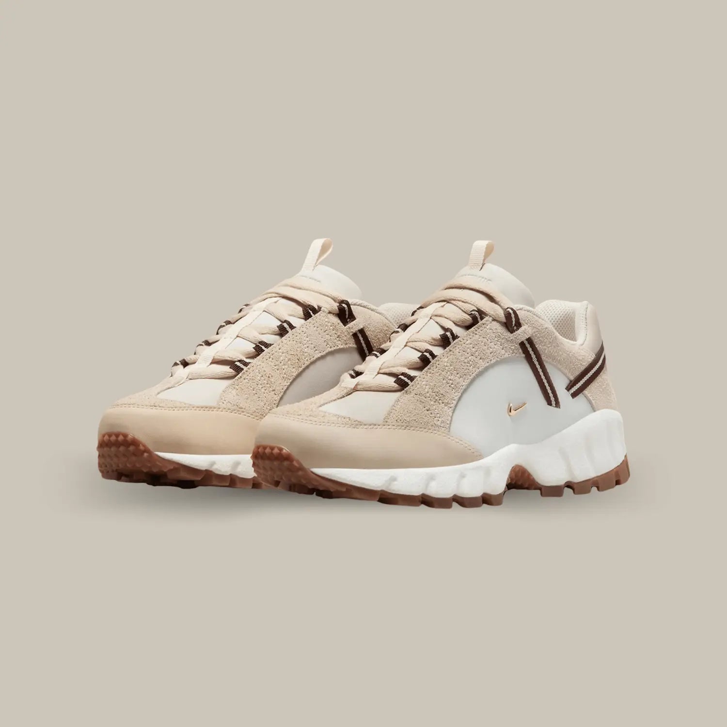 La Nike Air Humara LX Jacquemus Beige possède une base en cuir lisse blanc avec deux petit swoosh doré représentatif de la collaboration avec Jacquemus. On retrouve du cuir et du suède crème et une sangle qui accompagne les lacets.