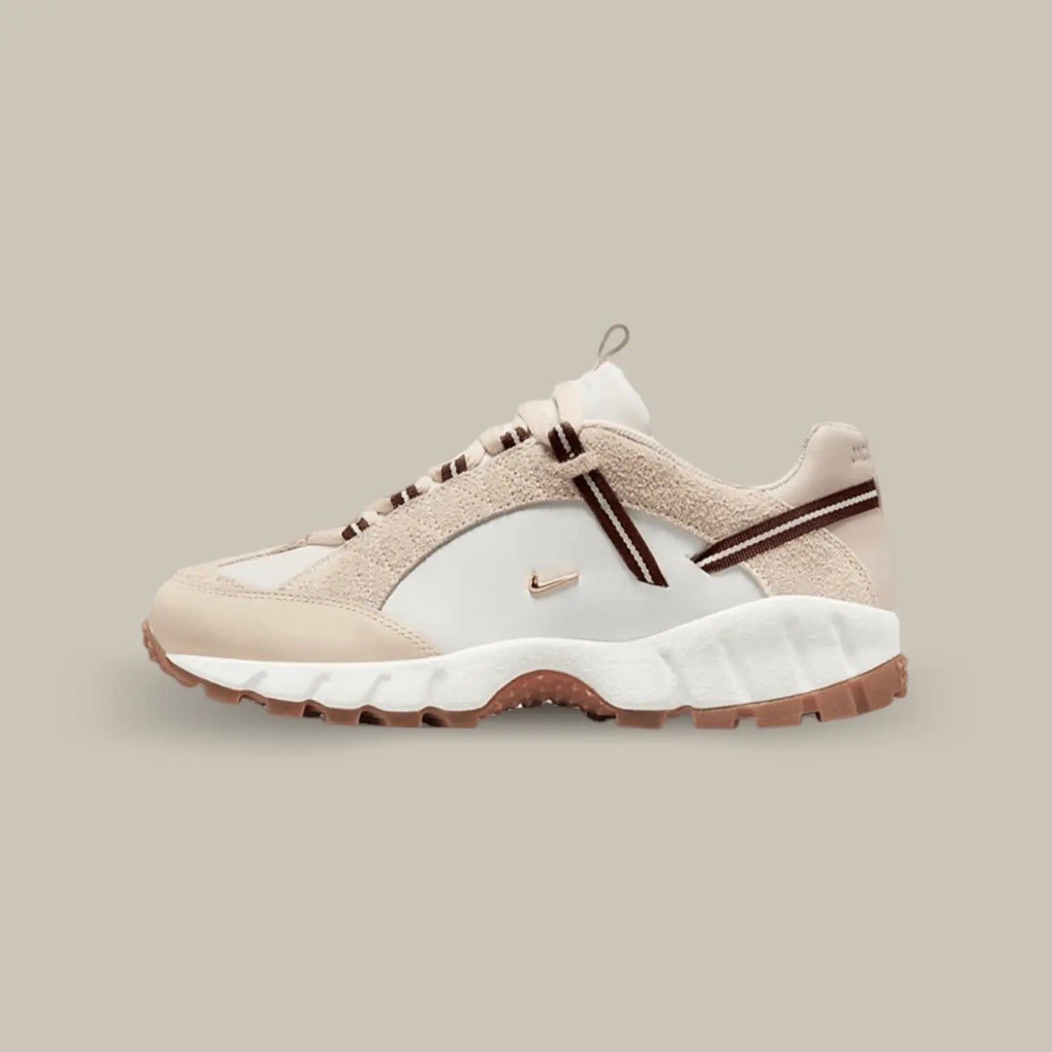 La Nike Air Humara LX Jacquemus beige de coté avec sa base en cuir lisse blanc et ses deux petit swoosh représentatif de la collaboration avec Jacquemus.