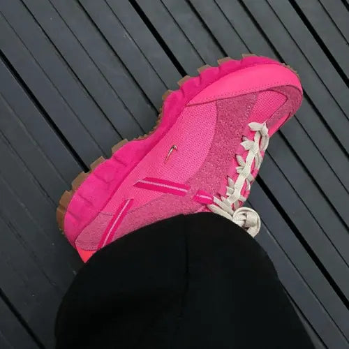 La Nike Air Humara LX Jacquemus Rose portée avec un pantalon noir.