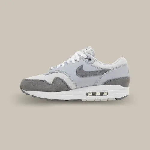Nike Air Max 1 '87 Photon Dust Wolf Grey vue latérale, sneaker grise en mesh et suede avec bulle d’air visible, silhouette rétro emblématique alliant style classique et confort moderne.