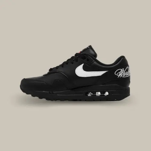 La Nike Air Max 1 '87 SP Supreme Black White vue de côté avec sa base en cuir noir et son swoosh blanc accordé aux écritures sur le talon "World Famous".