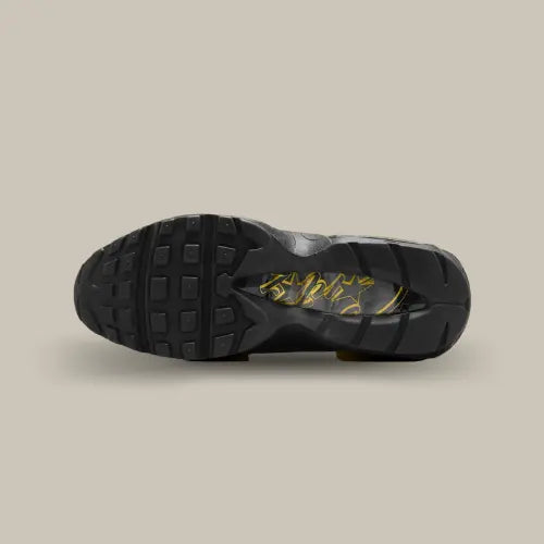 La semelle de la Nike Air Max 95 Corteiz Honey Black de couleur noir avec le logo Corteiz écrit en jaune au milieu de la semelle.