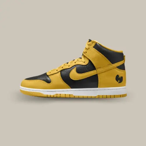 La Nike Dunk High Wu-Tang (2024) vue de côté avec sa base en cuir noir et ses empiècements de couleur jaune. On retrouve un swoosh de couleur jaune et le logo du Wu Tang Clan en noir au niveau du talon.