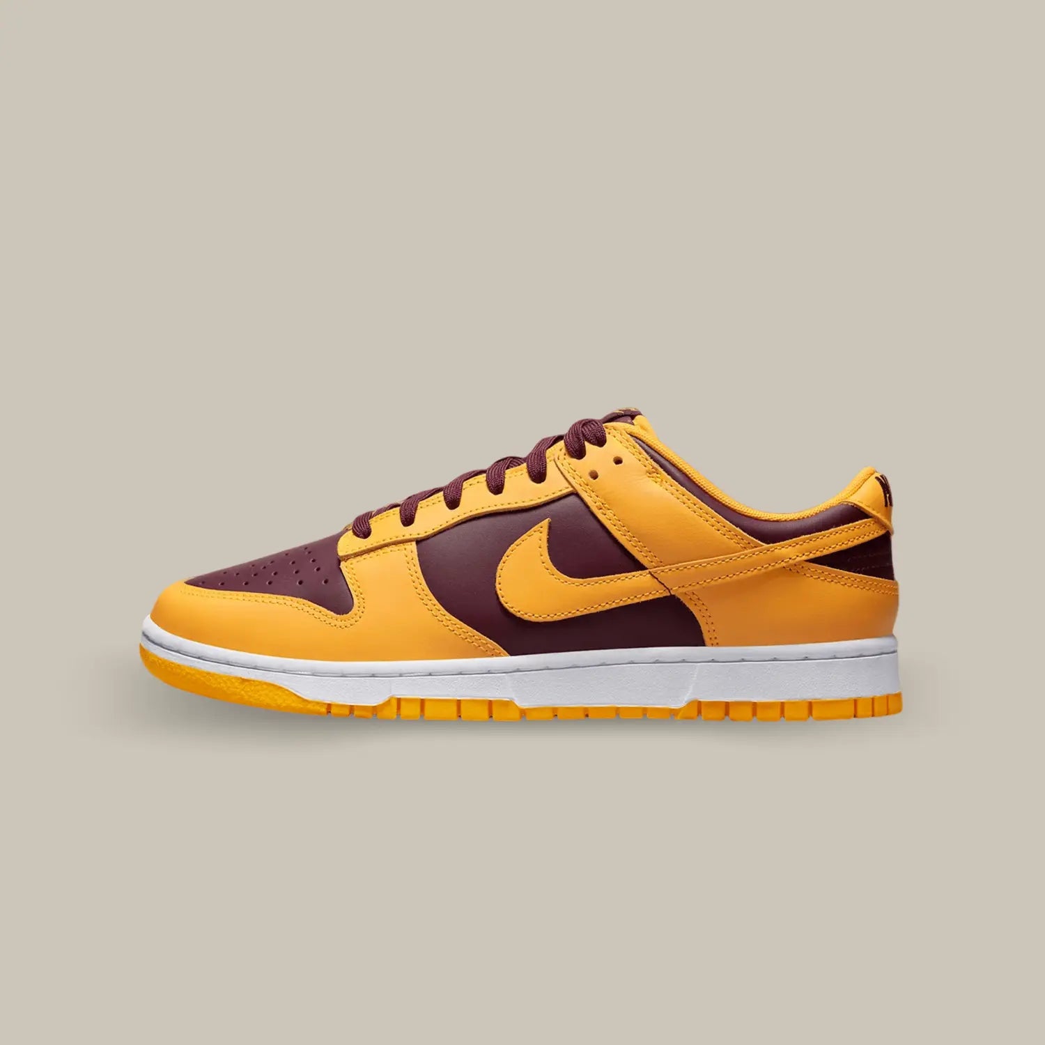 La Nike Dunk Low Arizona State de coté avec sa base en cuir bordeaux accompagnée de cuir jaune qui rappelle les équipes sportives de l’université d’Arizona State.