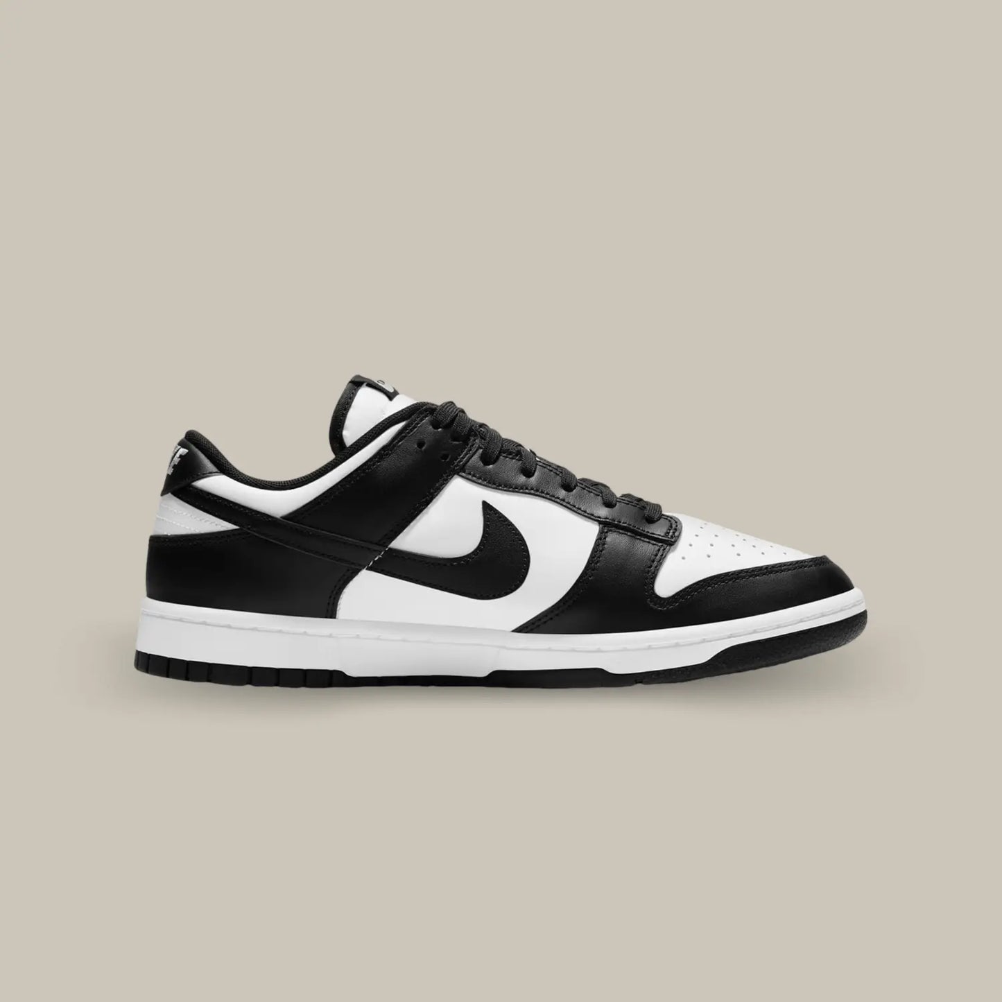 La Nike Dunk Low Black White de coté avec sa tige en cuir blanc, rehaussée par des empiècements en cuir noir pour un contraste tout en sobriété.