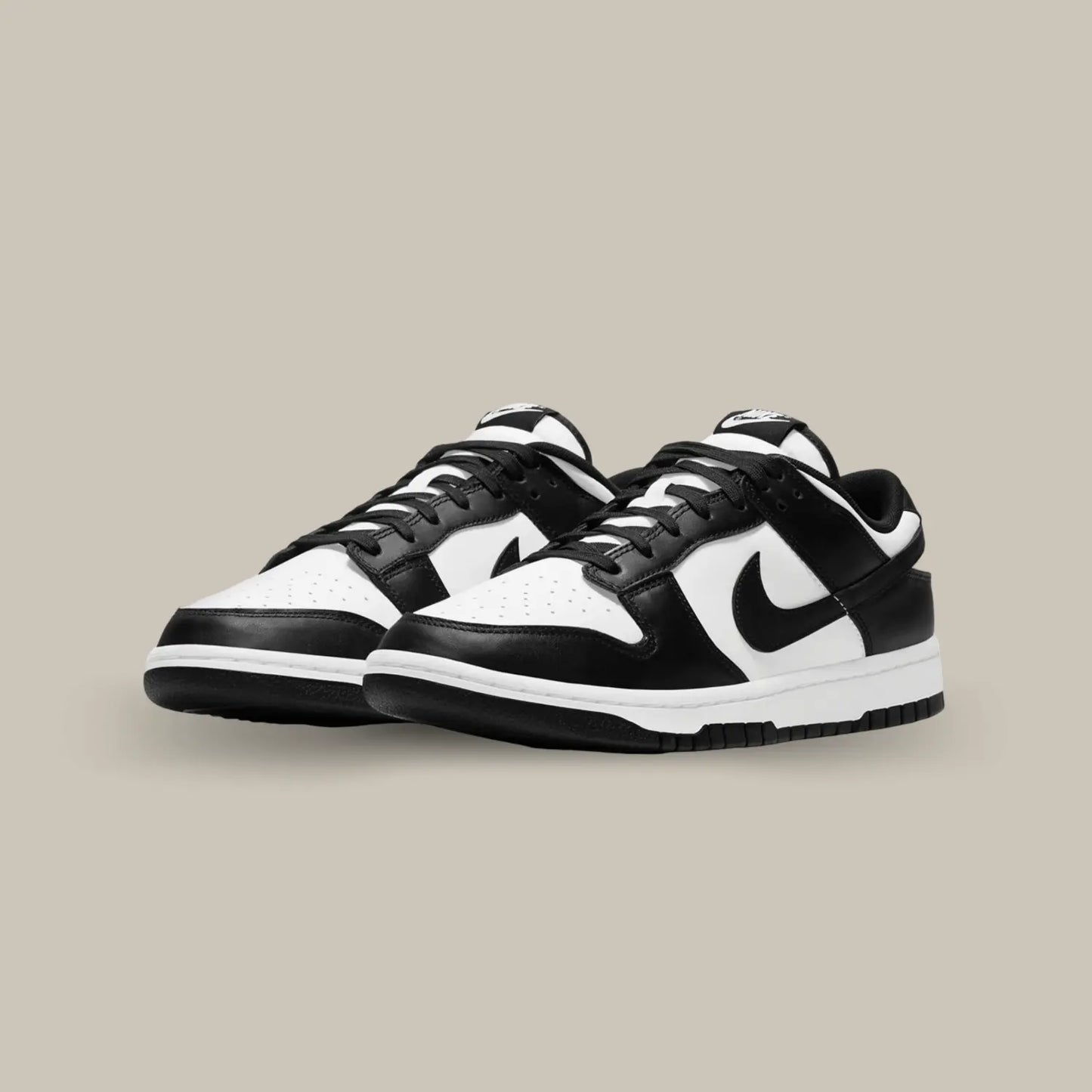 La Nike Dunk Low Black White arbore une tige en cuir blanc, rehaussée par des empiècements en cuir noir pour un contraste tout en sobriété.