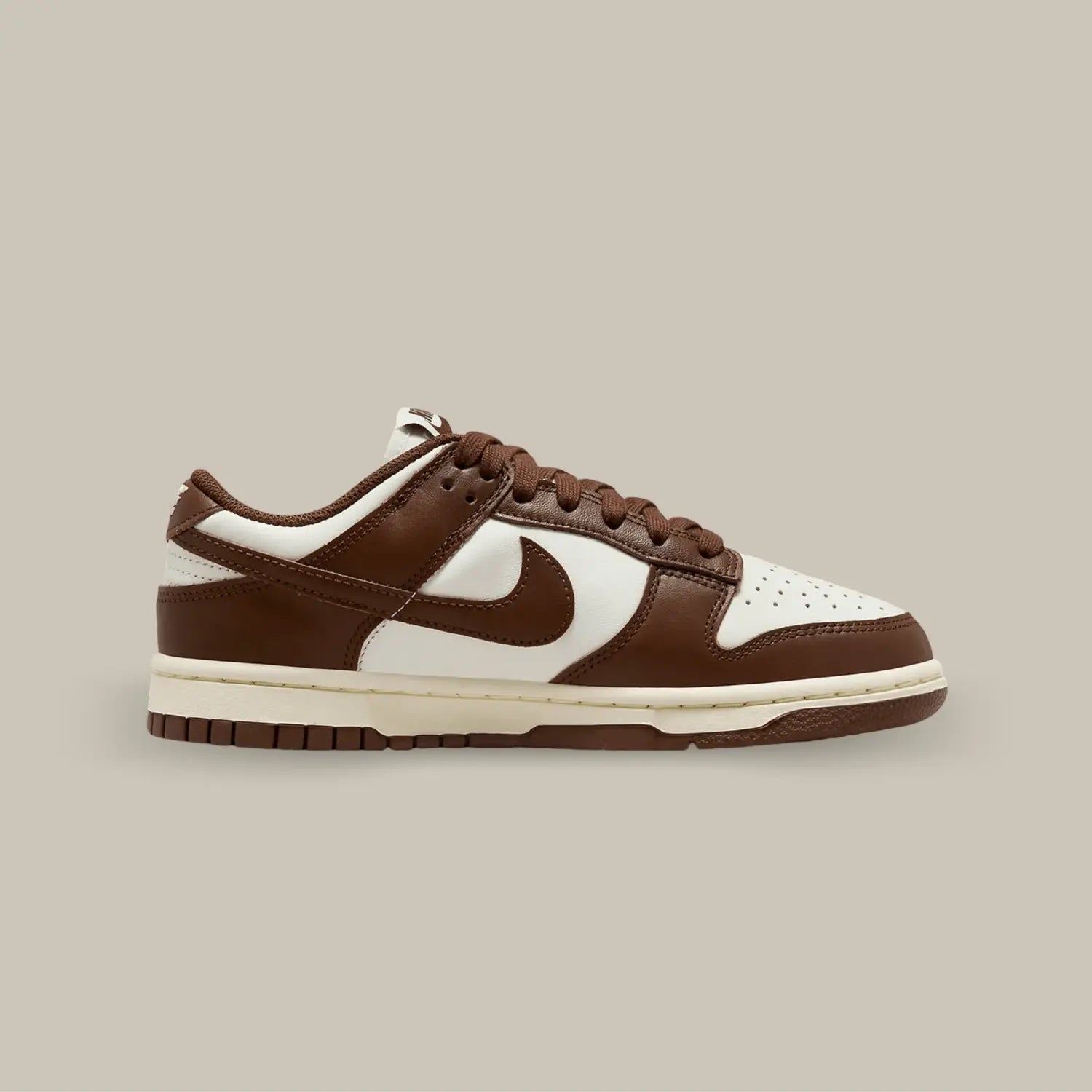 La Nike Dunk Low Cacao Now possède une base en cuir blanc avec des superpositions marron. On retrouve des lacets marrons assortis au célèbre swoosh de la marque de Portland.