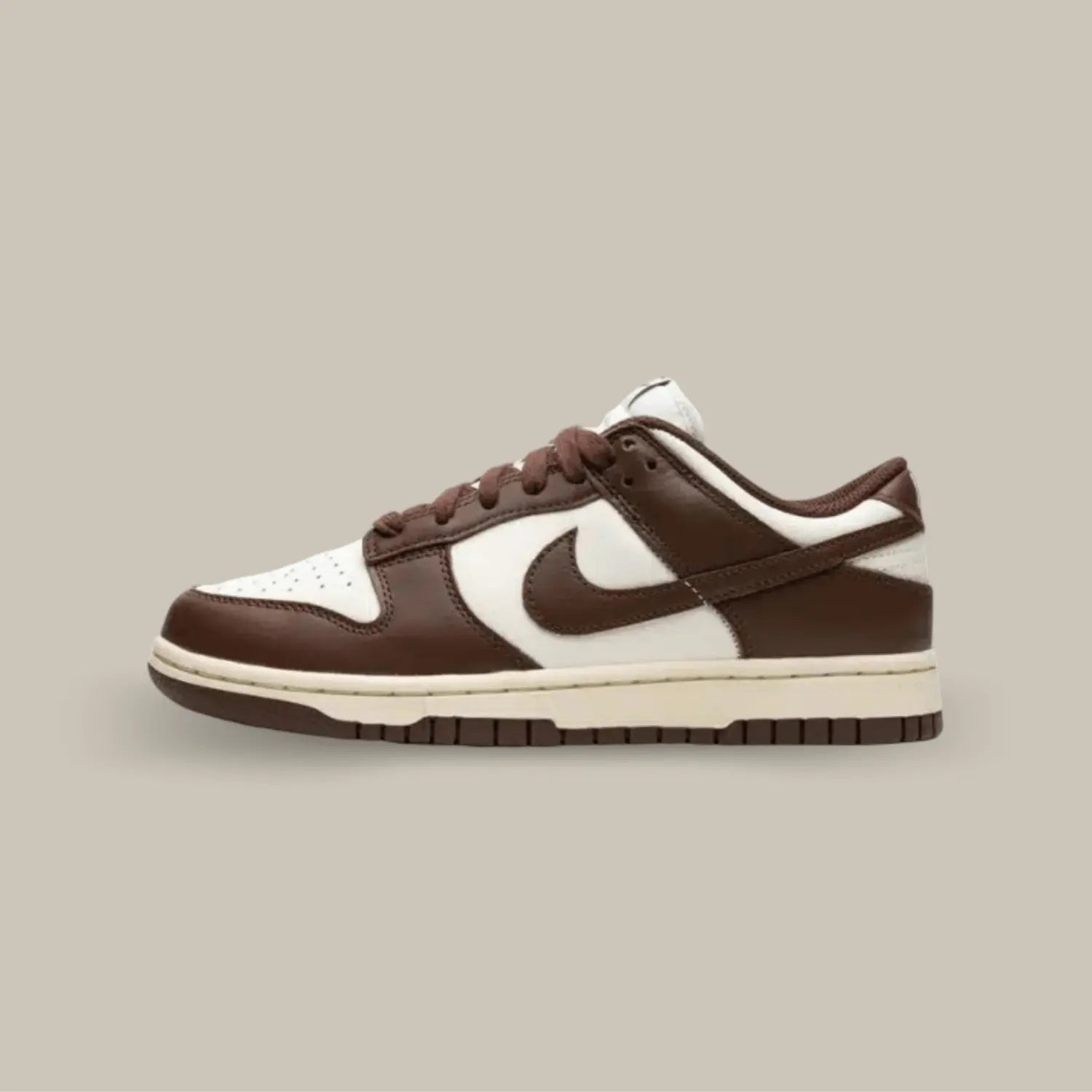 La Nike Dunk Low Cacao Now possède une base en cuir blanc avec des superpositions marron. On retrouve des lacets marrons assortis au célèbre swoosh de la marque de Portland.