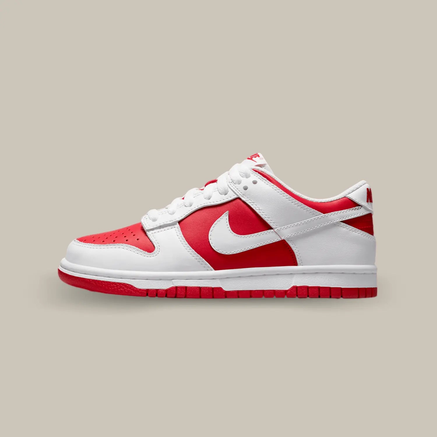 La Nike Dunk Low Championship Red de coté avec sa base en cuir rouge vif, sublimée par des superpositions en cuir blanc.