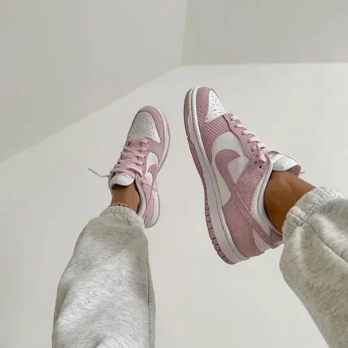 La Nike Dunk Low Corduroy Pink portée avec un jogging gris.