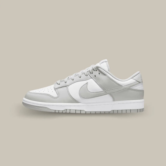 La Nike Dunk Low Grey Fog de coté avec son empeigne en cuir blanc, relevée d’empiècements en cuir gris clair.