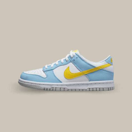 La Nike Dunk Low Homer Simpson de coté avec une base blanche, des empiècements bleu clair et un swoosh jaune à l'image de Homer Simpson.
