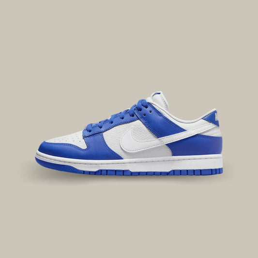 La Nike Dunk Low Kentucky Alternate de coté avec sa base en cuir grainé blanc aux superpositions de cuir bleu royal.