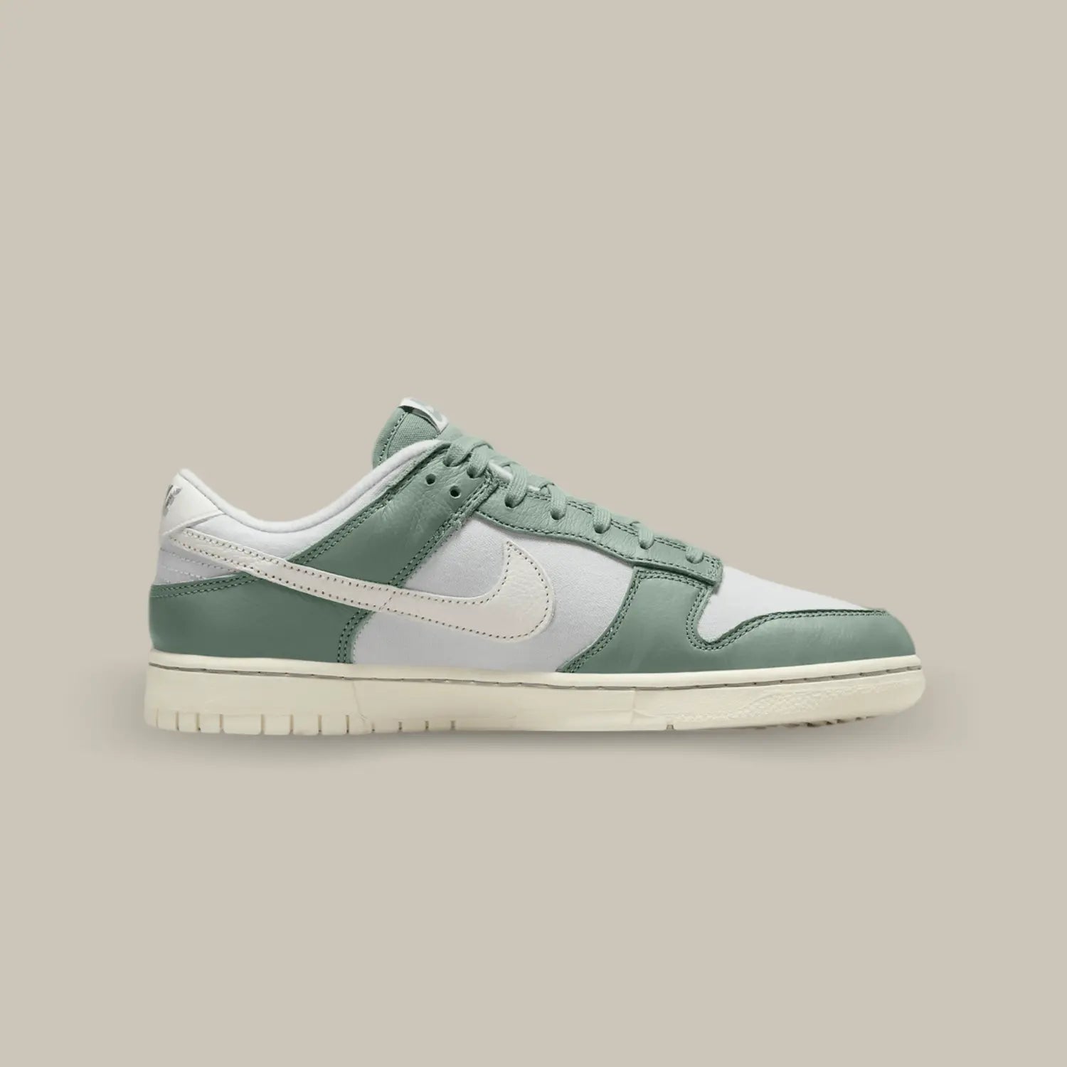 La Nike Dunk Low Mica Green de coté avec sa base en tissu gris, accompagnée par des superpositions en cuir vert.