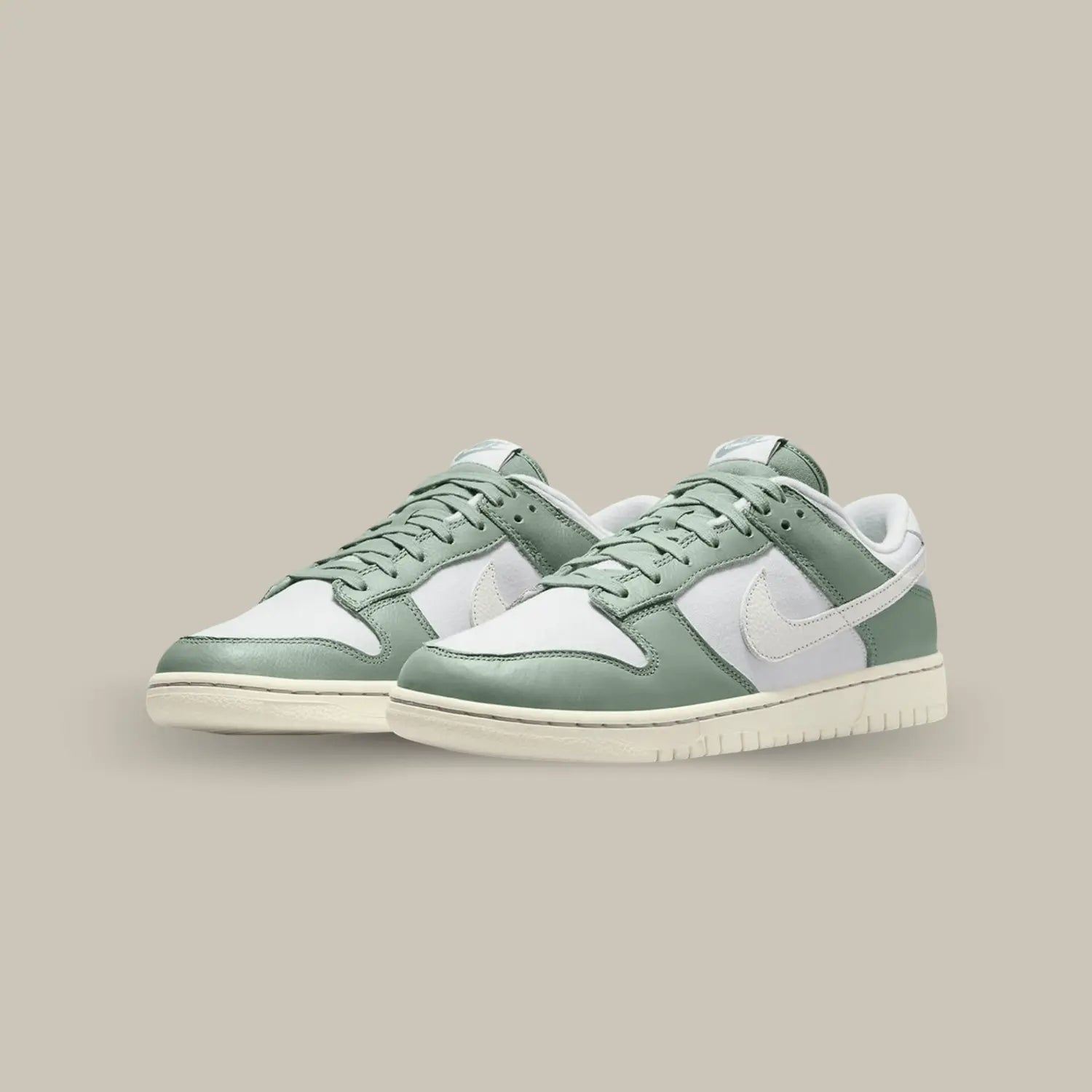 La Nike Dunk Low Mica Green se pare d’une base en tissu gris, accompagnée par des superpositions en cuir vert.