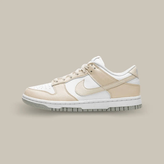 La Nike Dunk Low Next Nature White Light Orewood Brown de coté avec sa base en cuir blanc recyclé avec des empiècements en cuir crème. On retrouve le swoosh en cuir crème ainsi qu’une semelle grise qui vient compléter cette sublime Dunk.