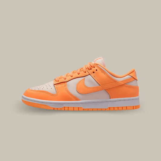 La Nike Dunk Low Peach Cream de coté avec sa base en cuir crème à la teinte douce. Plusieurs éléments de cuir orange s’ajoutent à la structure et nous rappelle le code couleur d’une pêche.