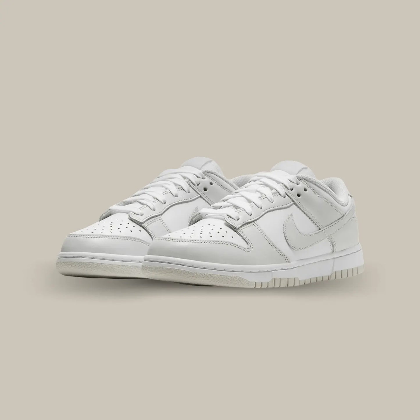 La Nike Dunk Low Photon Dust possède une base de cuir blanc pourvue d’empiècements en cuir gris. On retrouve un rendu sobre grâce aux deux couleurs qui s’entremêlent.