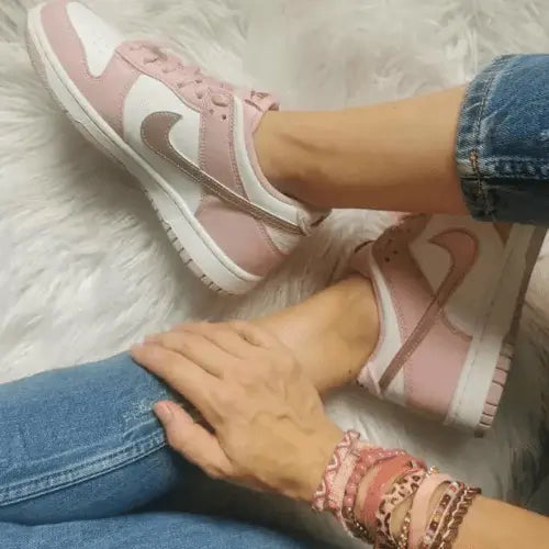 La Nike Dunk Low Pink Velvet portée avec un jean bleu.
