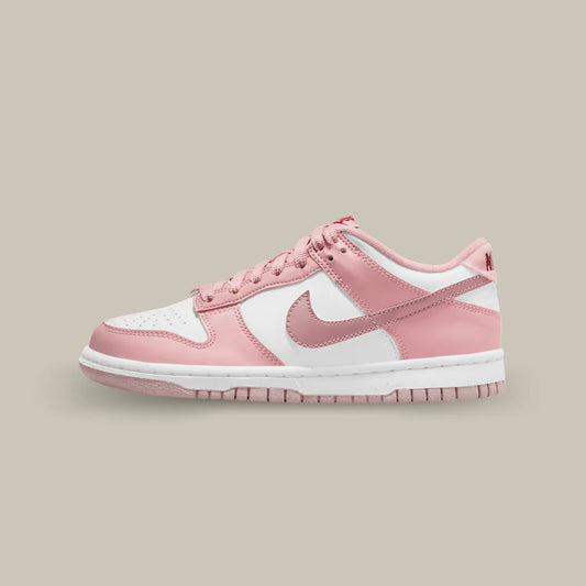 La Nike Dunk Low Pink Velvet de coté avec une empeigne en cuir lisse blanc, couplée à superpositions en cuir rose clair.