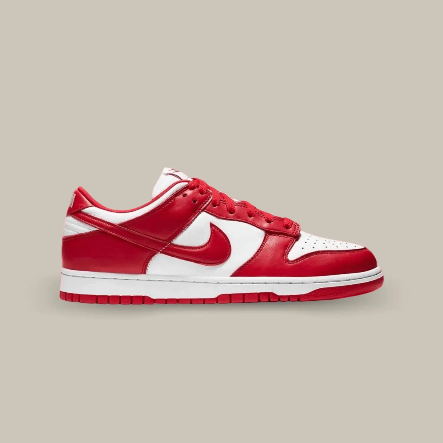 La Dunk Low University Red de coté avec une base en cuir blanc accompagné d'empiècements rouge.