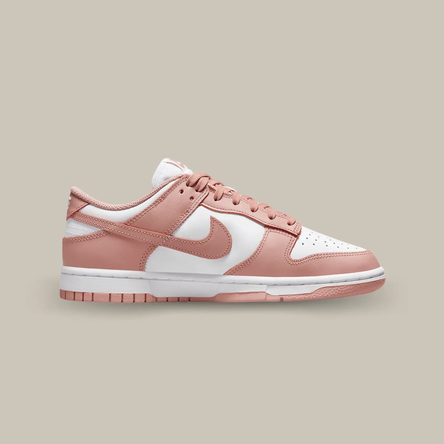 La Nike Dunk Low Rose Whisper de coté avec sa tige en cuir blanc aux superpositions de cuir rose pêche.