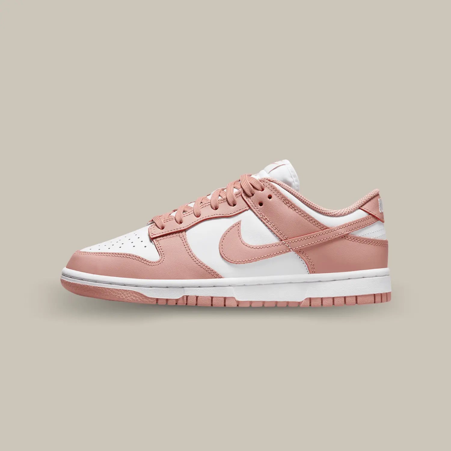 La Nike Dunk Low Rose Whisper de coté avec sa tige en cuir blanc aux superpositions de cuir rose pêche.