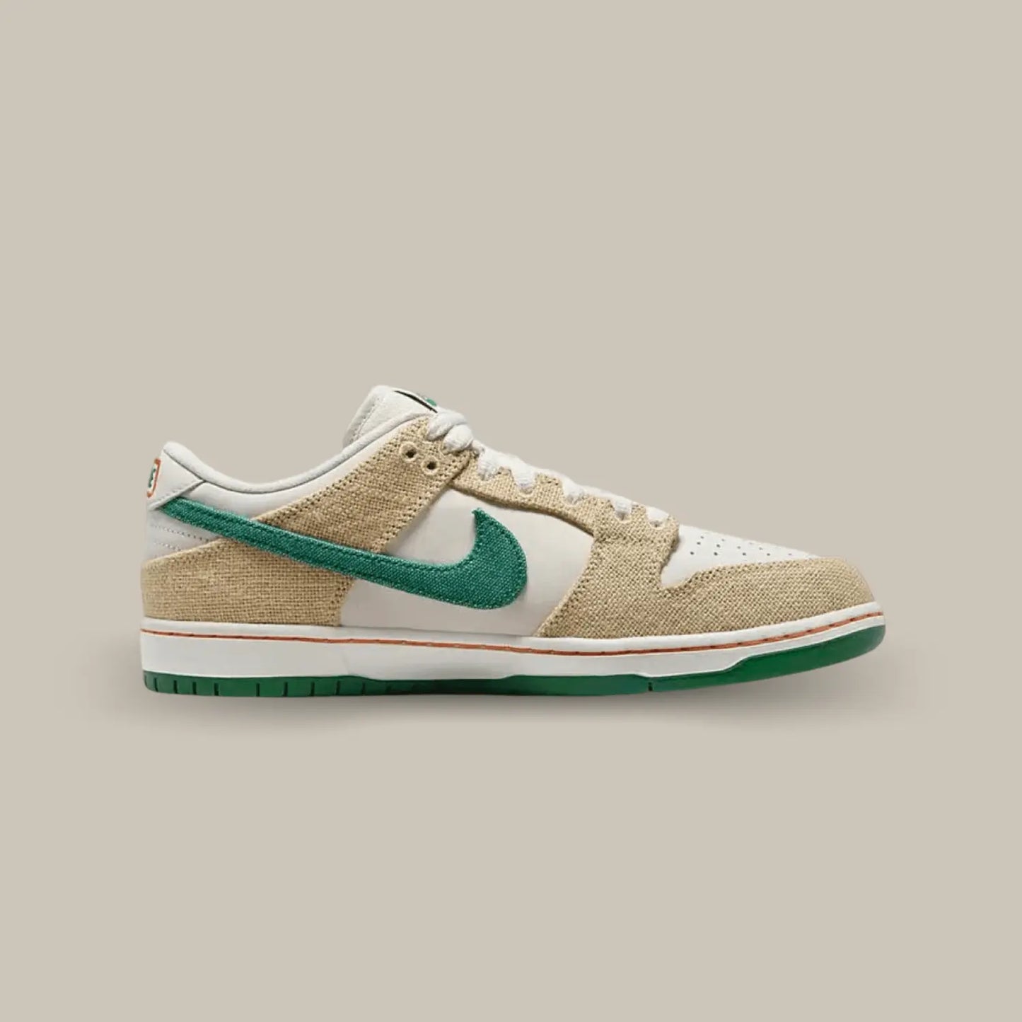 La Nike SB Dunk Low Jarritos de coté avec une base en cuir blanc, surmontée d’empiècements en toile beige faisant écho aux sacs utilisés pour récolter les fruits destinés à aromatiser les boissons. On retrouve également un swoosh en toile verte et une boisson brodée sur le talon.